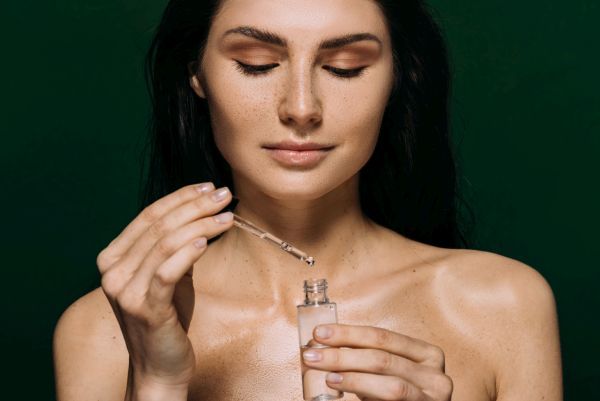 Eine Frau träufelt Flüssigkeit aus einer Pipette in ein Gefäß