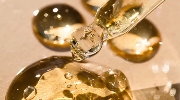 Ein paar goldene Tropfen aus einer Pipette