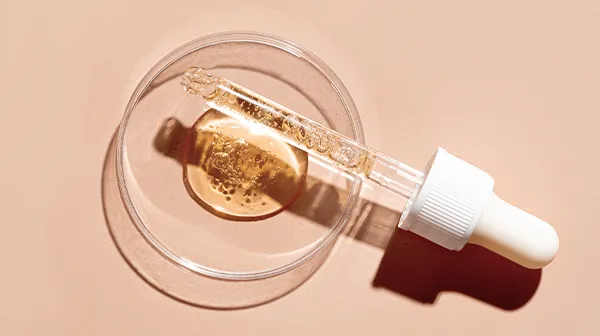 Eine gefüllte Pipette auf goldigem Hintergrund